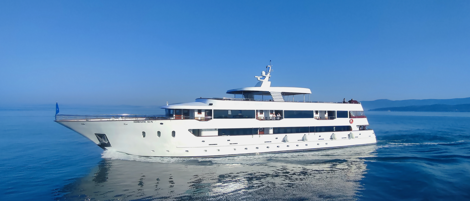 Small cruise ship sailing near the historic walls of Dubrovnik on a Croatia cruise tour