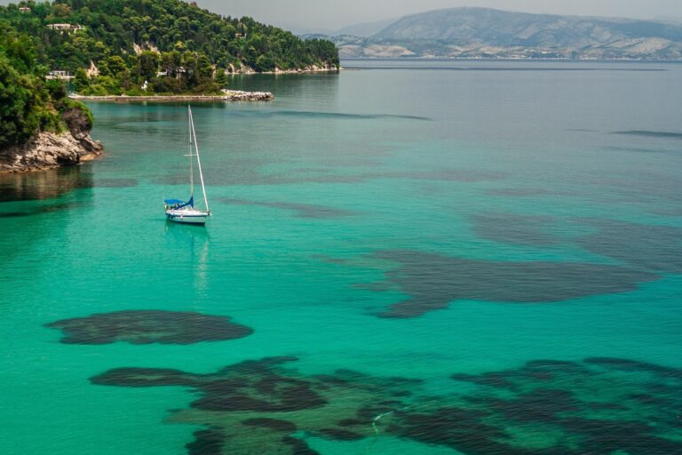 Turquoise water and moored boat in a sheltered Corfu bay, Greece